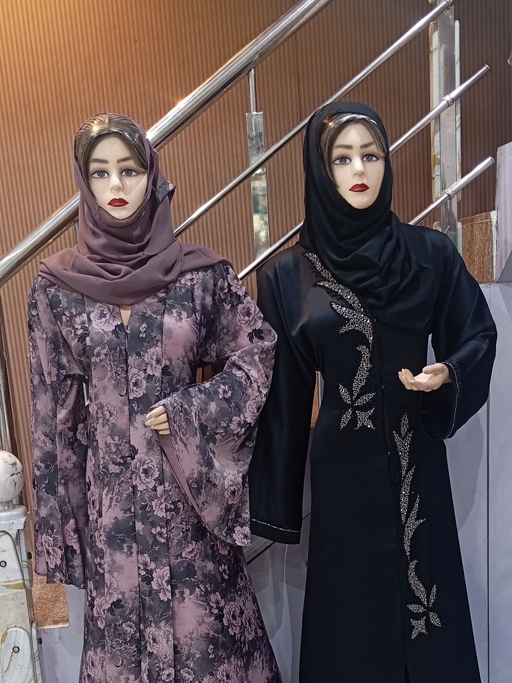 Two mannequins at Dubai Burqa Collections wearing floral and embroidered abayas with matching hijabs