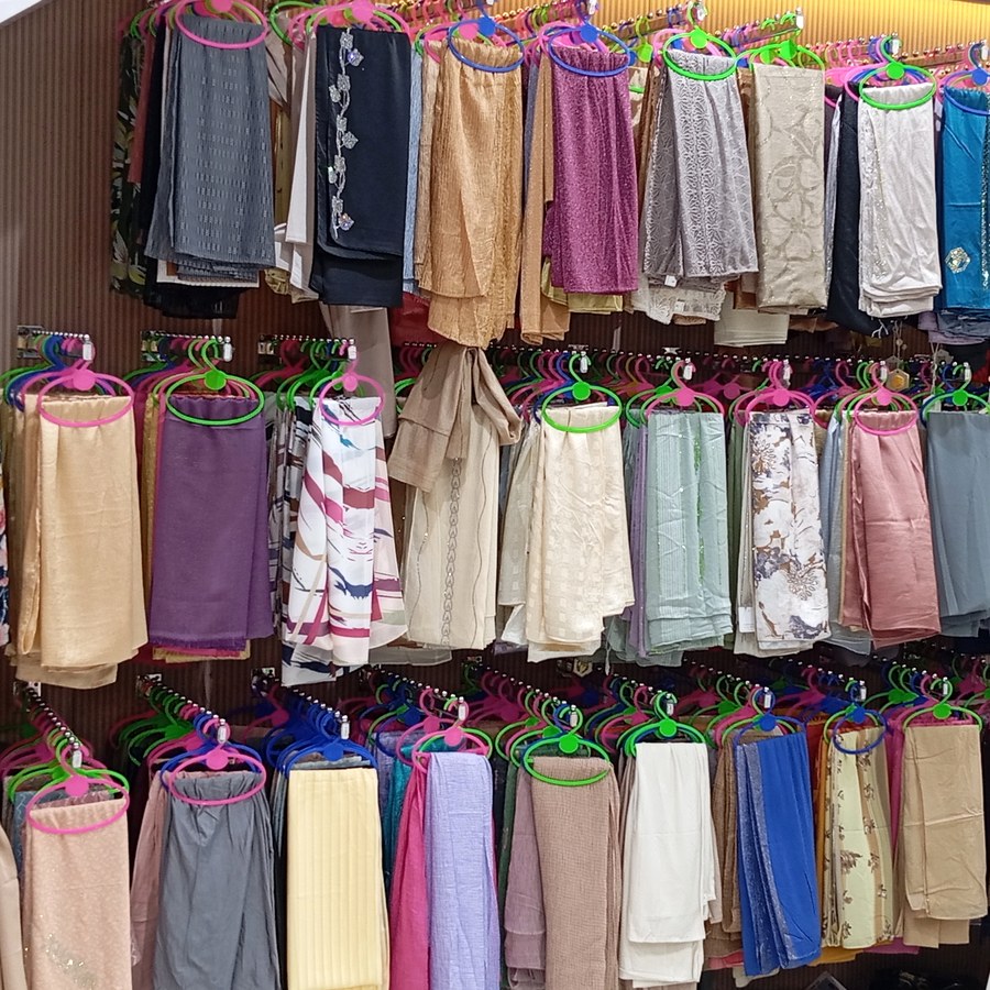 Colourful embellished garments hanging on display rails