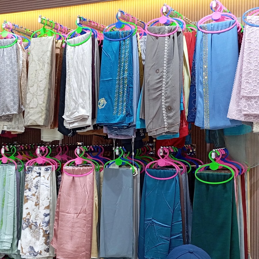 Rows of colourful hijabs and scarves on hangers